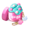 Gui Gui Mini Gloss Slime open pink jar with teal glossy slime topped with pom poms and pink bear and blue bow keychain charms