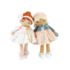 Two stuffed dolls standing next to each other, one in a ballet outfit and the other wearing a jacket and pink skirt.
